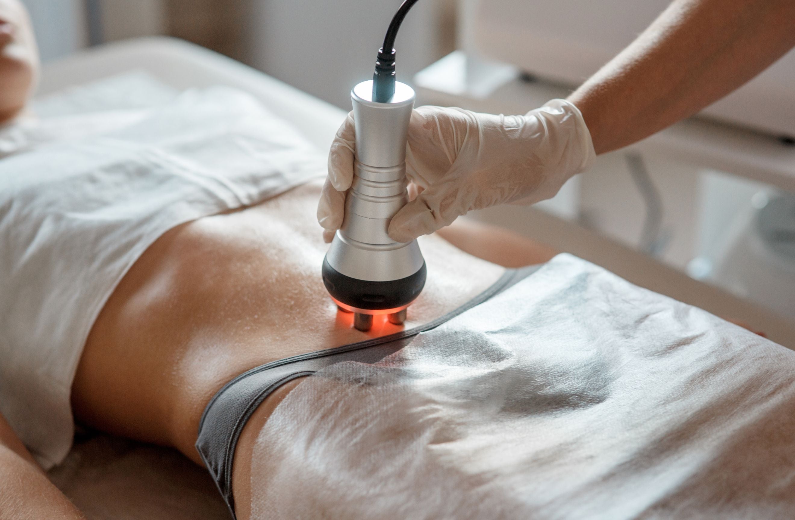 Woman on bed receiving red light therapy